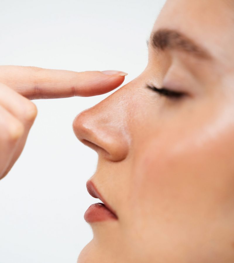 Close-Up Rhinoplasty To Reshape The Nose And Improve Breathing. Attractive Girl Touches Her Nose Before Septoplasty